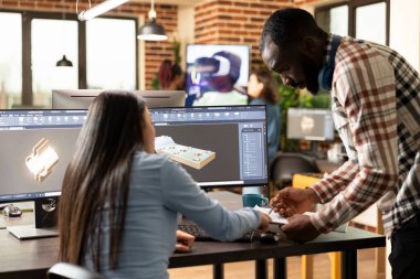 Profesyonel erkek ve kadın mühendisler CAD araçlı endüstriyel motor prototipi tasarlıyorlar. Çeşitli yaratıcı uzmanlar fikir alışverişinde bulunuyor ve çoklu monitörde mekanik bileşenler çiziyorlar..