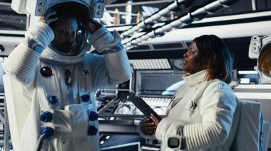 Astronot kaskını takıyor ve uzay istasyonundan çıkmadan önce liderden görev brifingi alıyor. Kozmonot gezegene indikten sonra yıldızgemisini terk etmeye hazırlanıyor.