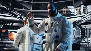 Astronot dalgaları, Dünya Komuta Merkezi ile video görüşmesi sırasında uzay gemisinde görev güncellemesini paylaşırken el ele veriyor. Kozmonot yer merkeziyle iletişim kurarken araştırmacıları selamladı