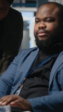 Dikey Video Siyah mühendisleri teknisyenleri bir güneş paneli fabrikasında fikirlerini paylaşıyor, projeleri gözden geçiriyor ve yenilenebilir enerji üretimini ve sürdürülebilir yenilikleri geliştirmek için fikirlerini paylaşıyor