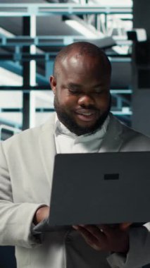 Veritabanı 'nda gülen bir mühendis sistem istikrarı için dizüstü bilgisayar kullanarak yazılım güncellemelerini yönetiyor. Sunucu çiftliğindeki mutlu çalışan performansı optimize ediyor, altyapıyı yapılandırıyor