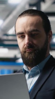 Güneş panellerinin üretim çıktısını izleyen takım elbiseli dikey video fabrikası müfettişi, profesyonel işgali ve temiz enerji gelişimine idari düzeyde katılımı yansıtıyor. Güneş enerjisi