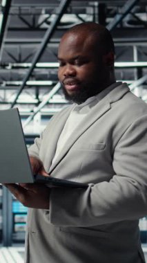 Veritabanında dizüstü bilgisayar kullanan dikey bilgisayar bilimcisi sunucunun sanal hale getirilmesini yönetiyor. Sunucu odasında not defteri kullanan Afrikalı Amerikalı bir adam, altyapının güvenilirliğini sağlıyor, kamera A