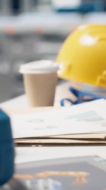 Dikey Video Yüksek Teknoloji imalat ortamı robotikleri iş başında, fotovoltaik sistem izleme ve bir masada gerekli güvenlik ekipmanlarını gösteriyor. Modern yenilenebilir enerji üretim hattı.