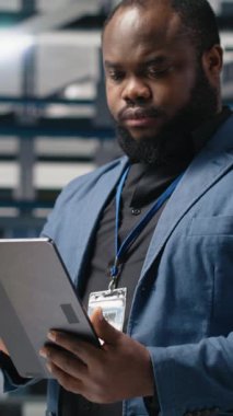 Dikey Video Siyah Sanayi uzmanı yenilenebilir enerji başarısını sürdürmek için yenilik ve verimliliği güvence altına alan bir güneş teknolojisi tesisinde üretim verilerini inceliyor. Çevre dostu sürdürülebilir çözümler