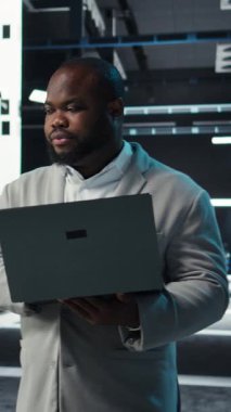 Ana bilgisayarlar için yazılım güncellemeleri yaparak dizüstü bilgisayarda kodlama yapan dikey video veri merkezi mühendisi. Sunucu çiftliği bilişim uzmanı klavyeye yazı yazıyor, altyapıyı optimize ediyor, kamera A