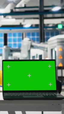 Güneş panellerindeki dizüstü bilgisayarda, sürdürülebilir çözümler ve temiz enerji için güneş pili mühendisliği üreten dikey video izole edilmiş kroma ekranı. Yüksek teknolojili bir tesiste boş masa..