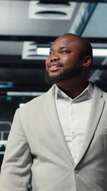 Dikey video gülümseyen mühendis veri merkezinde yürüyor, sistem istikrarı için donanımı kontrol ediyor. Mutlu çalışan sunucu çiftliği denetleme, performansı optimize etmek için altyapıyı yapılandırma, kamera B