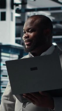 Dikey video sunucusu oda çalışanı bilgisayardaki yazılımı kullanarak zayıf noktaları denetliyor. Veri merkezinde yürüyen mühendis not defteri, kamera B kullanarak yedekleme ve kurtarma protokolleri yapıyor