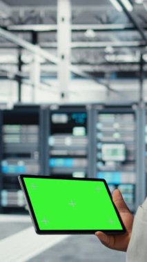 Veri merkezinde, afet kurtarma planlarını geliştirmek için yeşil ekran tableti kullanan dikey video mühendisi. Sunucu çiftliği testlerinde IT uzmanı model aygıtı üzerinde başarısız senaryolar, veri korunması sırasında