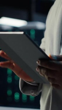 Sunucu merkezindeki dikey video bilişim uzmanı tablet kullanarak potansiyel tehditlerden korunan değerli verileri sağlıyor. Yetkisiz erişime karşı veri merkezini koruyan işçiler ve