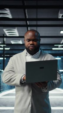 Sistem istikrarını sağlamak için dizüstü bilgisayar kullanan dikey video veri merkezi bilgisayar bilimcisi. Sunucu odası bilişim uzmanı aygıtla performansı optimize ediyor, ekipman donanımları yapılandırılıyor, kamera A