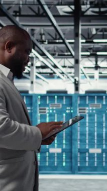 Tablet üzerindeki yazılımı kullanarak dikey video sunucu odası mühendisi sorun çıkaran arka uç işlemleri. Jolly veri merkezi programcısı, aygıt, kamera A kullanarak hataları düzeltmek için yazılım yamaları derliyor