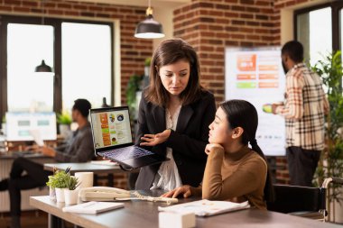 Profesyonel pazarlamacı interneti reklam stratejileri sergilemek, müşteri verilerini modern çalışma alanında analiz etmek için kullanıyor. İş analizlerine yoğunlaşan iki kadın iş arkadaşı dizüstü bilgisayarda.