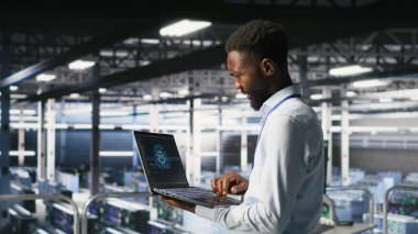 Veri merkezindeki programcı ve meslektaşım bilgisayardaki AI LLM görselleştirmelerini inceliyor. IT ekip çalışanları, istikrarlı altyapı işlemleri sağlamak için nöral ağ performans çıktılarını analiz ederler