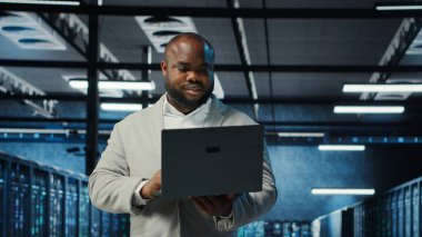 Veri merkezi mühendisi ekipman performansını analiz ediyor, teknik sorunları çözüyor. Sunucu çiftliği çalışanı işlerini yapıyor, operasyonları denetliyor, verimlilik optimizasyonlarını uyguluyor, kamera B