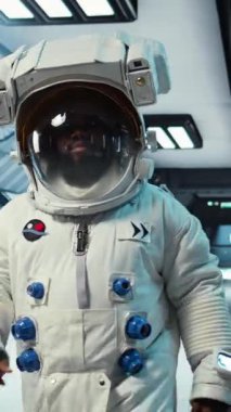 Dikey video bilimci miğfer takıyor son teknoloji uzay gemisinde yürüyor, güneş sisteminde kozmik yolculuk yapıyor. Yörünge istasyonunda kozmonot kıyafeti giyen Afro-Amerikan astronot, kamera A