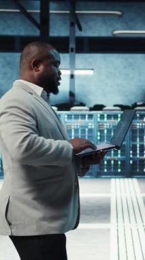 Alt yapı yapay zeka öğrenme otomatikleştirmesi için dizüstü bilgisayar kullanan dikey video sunucu odası yöneticisi. Yüksek teknoloji veri merkezinde yapay zeka kullanarak bakım yapan bir bilişim uzmanı.