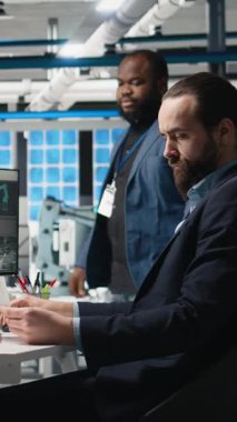 Çeşitli mühendislerin dikey video portresi, fotovoltaik üretimi için sürdürülebilir teknoloji ve endüstriyel faaliyet sağlayan, işbirlikçi bir denetimin parçası olarak güneş paneli sistemlerini yöneten