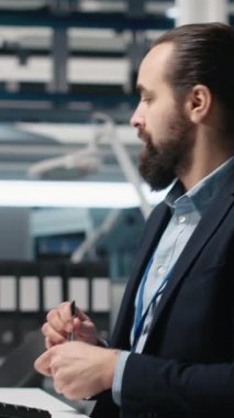 Vertical Video Professional Mühendisi güneş panelleri tesisinde bilgisayar görüşünü inceleyerek, üretim hattı ve kalkınma hedefleri için alternatif enerji sistemlerini güvence altına almak için bir teftiş yürütüyor. Kamera.