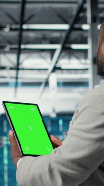 Veri merkezinde, afet kurtarma planlarını geliştirmek için yeşil ekran tableti kullanan dikey video mühendisi. Sunucu çiftliği testlerinde IT uzmanı model aygıtı üzerinde başarısız senaryolar, veri korunması sırasında