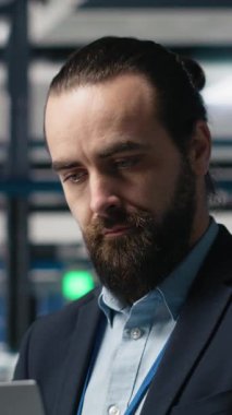 Güneş paneli montaj hattını izleyen bir giysi içindeki dikey Video Tesis Yöneticisi, yenilenebilir enerji büyümesinde profesyonel işgal ve idari düzeyde katılımı yansıtıyor. Dayanıklılık. Kamera.