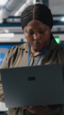 Dikey Video Kadın usta mühendisi fotovoltaik için üretim hattını inceliyor, dizüstü bilgisayardaki üretim süreci verilerini gözden geçiriyor. Endüstriyel işlemler için alternatif enerji başarısı üzerinde çalışıyoruz