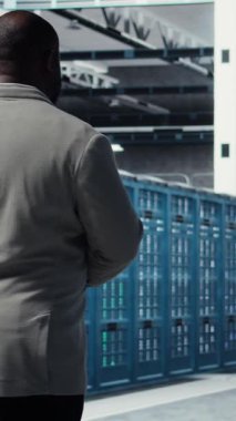Dikey video yönetimi veri merkezinde yürüyor, altyapı teknisyenlerinin kullanıcı taleplerini inceliyor. Bilgi işlem uzmanı sunucu çiftliğinde ekipman bileşenlerinin trafik modellerini analiz ediyor, kamera A