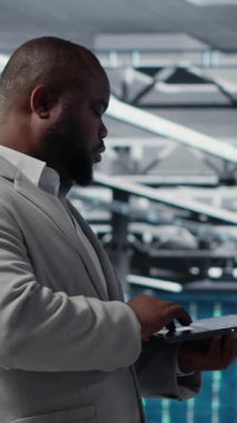 Tebessüm Veri Merkezi teknisyeninin donanım bileşenlerini yükleyip güncellediği dikey video. Happy sunucu çiftliği çalışanı görev yapıyor, veri kaybına karşı korumak için yedek çözümler uyguluyor