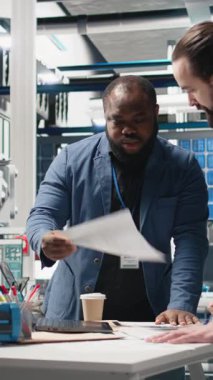 Dikey Video Teknisyenleri yüksek teknoloji tesisinde güneş paneli üretimini inceleyen iş adamları, alternatif enerji endüstriyel üretimindeki takım çalışması, verimlilik ve içgörüyü yansıtıyorlar.