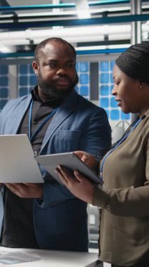 Dikey Video Afrikalı Amerikalı mühendisler bir güneş paneli tesisinde işbirliği yaparak üretim hattı altyapısını güvence altına almak ve alternatif enerji fikirleri paylaşmak için planlar üzerinde çalışıyorlar.