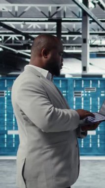 Yapay zeka sistemlerinin iş yükünü geliştirmek için dizüstü bilgisayar kullanan dikey video sunucu çiftliği bilişim uzmanı. Yapay zeka model parametrelerini ayarlamak için dizüstü bilgisayar kullanan veri merkezi yazılım geliştiricisi