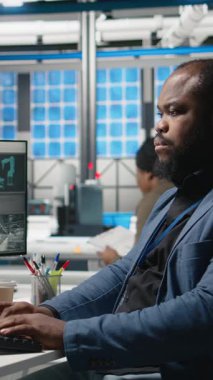 Dikey Video Afrikalı Amerikalı denetleyici güneş paneli makinelerini kontrol ediyor ve yenilenebilir enerji üretimi ve montaj hattında hayati bir rol oynayan bir kontrol listesini gözden geçiriyor. Güneş teknolojisi altyapısı