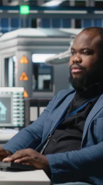 Dikey Afrikalı Amerikalı uzman ekibi, teftiş sırasında güneş paneli üretim sistemlerini inceleyerek mühendisliğin doğruluğunu ve kalite kontrolünü sağlıyorlar. Yüksek teknoloji endüstriyel fabrika. Kamera.