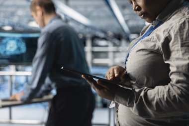 Tablet üzerindeki yazılımı kullanarak ağ yapılandırmalarını inceleyen sunucu odasını kapatın. Ekip çalışması veri merkezi teknisyenleri aygıt kullanarak kaynak kullanım eğilimlerini izliyor