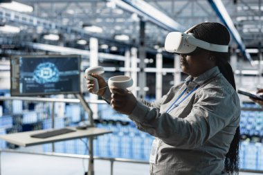 Sunucu odası çalışanı karmaşık yapay zeka hesaplamalarını hızlandırmak için VR donanımı kullanıyor. Veri merkezi mühendisi sanal gerçeklik teknolojisini kullanarak veri tabanlarını analiz ediyor, altyapı sistemlerini yönetiyor