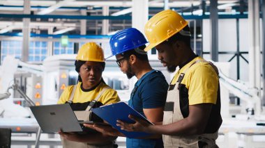 Fotovoltaik fabrikasındaki tüm siyah müfettişler belgeleri inceleyip, güneş panellerini montaj hattına yerleştiren robotların performanslarını inceleyecekler. Güneş pilleri tesisini denetleyen denetçiler. Kamera A.