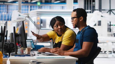 Fabrika işçileri analitik araçlar ve CAD yazılımı kullanarak PC 'de güneş enerjisi sistem tanılarını kontrol ediyorlar. Teknisyenler yenilenebilir enerji için arızalar tespit edip otomasyonu inceliyorlar. Kamera A.