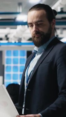 Resmi kıyafetli dikey video mühendisi danışmanı endüstriyel operasyonları inceliyor, iş uzmanlığı ve güneş teknolojisi üretim tesisinde verimliliği birleştiriyor. Alternatif enerji. Kamera B.