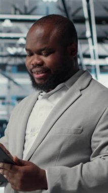 Verileri analiz etmek için tablet kullanarak sunucu çiftliğinde çalışan dikey video mühendisi. Bilgi İşlem Uzmanı, veri merkezindeki altyapıyı cihaz, sistem bütünlüğü ve güvenliğinin sağlanması, kamera B kullanarak inceliyor.