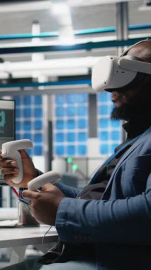 Dikey Video Siyah fotovoltaik fabrikası uzmanı, güneş panellerini yerleştirmek için robotik kollarla çalışan dijital güneş pillerini monte etmek için VR gözlükleri kullanır. Mühendis sanal gerçeklikte makineler kullanır.