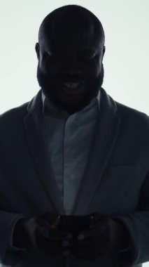 Dikey görüntülü gülen adam telefon uygulaması kullanıyor, kişisel video tavsiyelerini anında alıyor. Neşeli Adam dijital çağın tadını çıkarıyor. Sınırsız yayın olanağı sağlıyor. Kamera A.