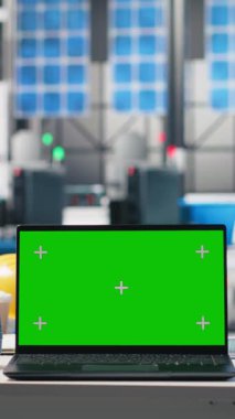 Boş fotovoltaik masasındaki bir dizüstü bilgisayardaki dikey video yeşil ekran, güneş panelleri üretim tesisinde enerji arzını optimize etmek için kullanılır. Yüksek teknoloji mühendisliği endüstrisi.