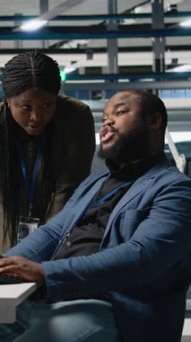 Dikey Video Siyah mühendisleri teknisyenleri bir güneş paneli fabrikasında fikirlerini paylaşıyor, projeleri gözden geçiriyor ve yenilenebilir enerji üretimini ve sürdürülebilir yenilikleri geliştirmek için fikirlerini paylaşıyor