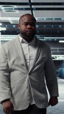 Yüksek teknoloji veri merkezinde, ağları çalıştıran, şirketlerin veritabanlarını çalıştıran, gülen, dikey video çalışanı. Geniş veri işleme modülleriyle sunucu çiftliğini denetleyen yönetici