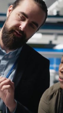 Yüksek teknolojili bir güneş paneli fabrikasında veri ve kontrol listelerini inceleyen profesyonel danışmanlardan oluşan dikey video grubu, üretim sürecinin sürdürülebilir enerji ve yenilik standartlarını karşılamasını sağlıyor