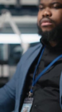 Dikey Video Siyah endüstriyel uzmanı, güneş paneli fabrikası kurarak, temiz sürdürülebilir enerji üzerinde çalışarak, bilgisayardaki montaj sürecini inceliyor. Üretim akışı için mühendislik yeniliği