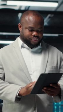 Veritabanında tablet kullanarak iş yükleri için altyapıyı sağlayan dikey gülümseyen bir yönetici. Sunucu çiftliğindeki neşeli bilişim uzmanı paralel işleme için yüksek teknoloji sunucu kümeleri kullanıyor