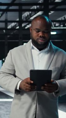 Dikey Veri Merkezi Mühendisi Yapay Zeka eğitimi ve çıkarım görevleri yapan sunucuları izliyor. Afrika kökenli Amerikan sunucu merkezi işçisi depolama sistemlerini yöneten bilgisayar platformlarını denetliyor, kamera A