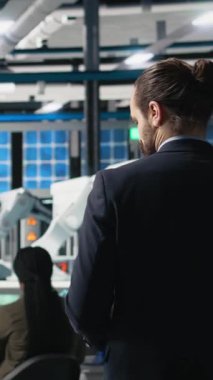 Modern fabrikadaki ekipman ve verimliliği inceleyerek, güneş panelleri üretim hattını yöneten dikey video mühendisi. İş adamı uzmanı alternatif enerji üzerinde çalışıyor. Kamera A.